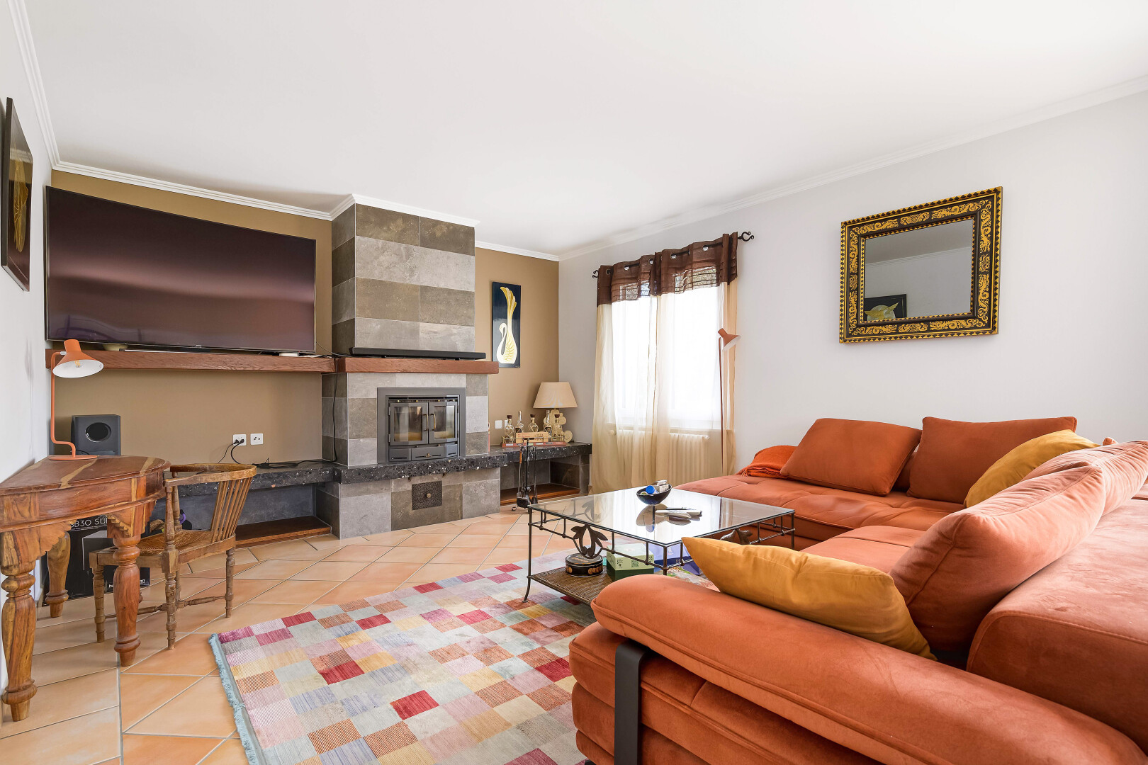 living area featuring crown molding, tile patterned floors, and a tile fireplace