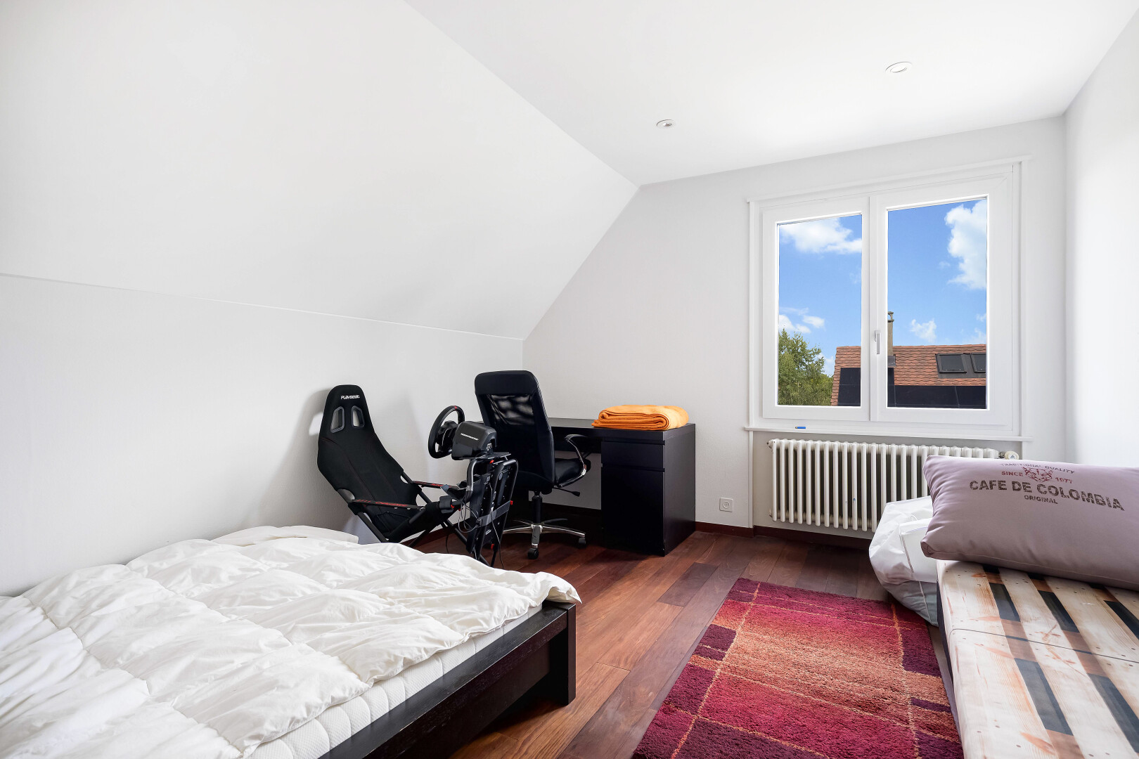 room / bedroom with dark wood-style floors, vaulted ceiling, radiator heating unit, and an office area