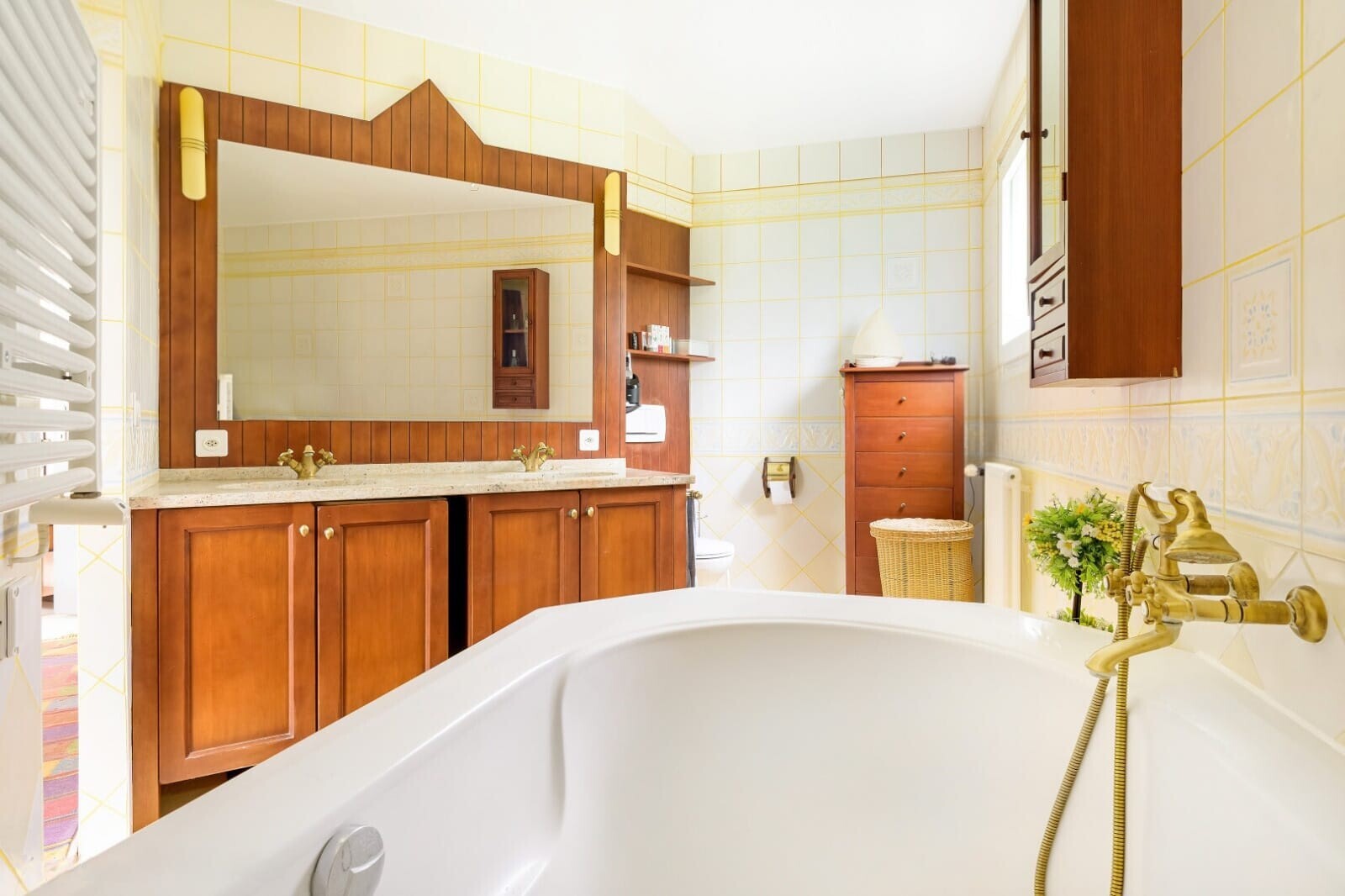 bathroom featuring a freestanding tub, double vanity, and tile walls