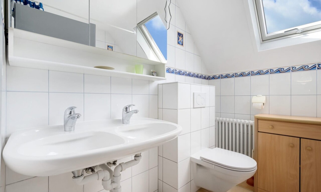 salle de bains avec radiateur, miroir, toilette, inside property, et tile wall
