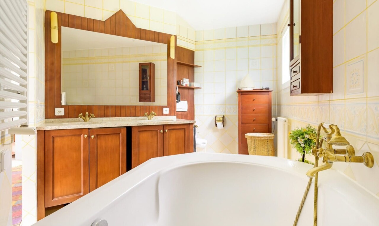 salle de bains avec salle de bain complète, miroir, bain, inside property, et double vasque