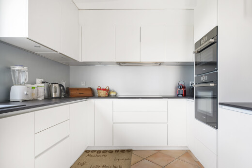 kitchen with white cabinets, modern cabinets, light tile patterned floors, and dark countertops