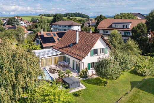 view of home featuring roof mounted solar panels, a patio, a yard, a residential view, and a chimney