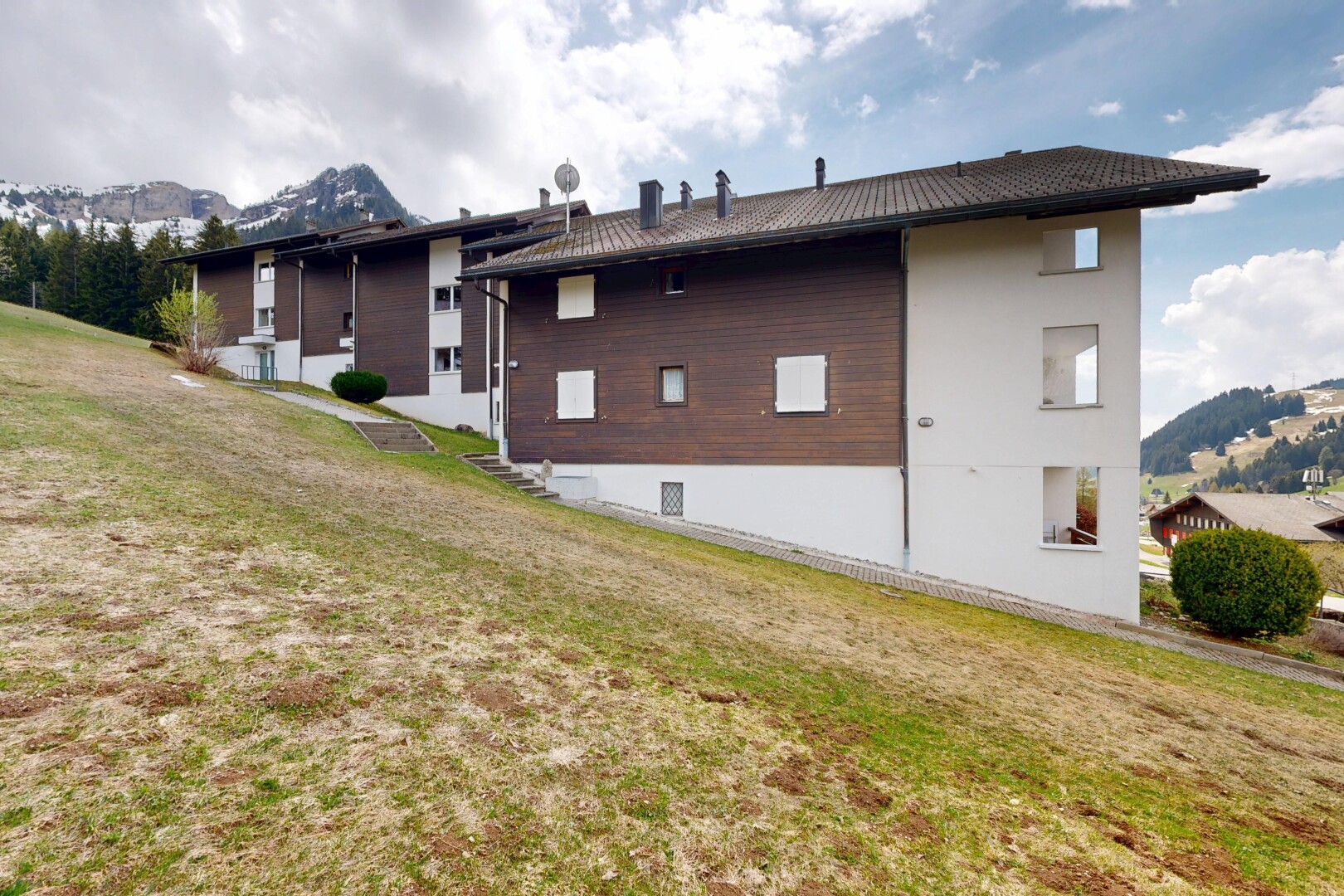 outdoor house with a mountain view and a lawn