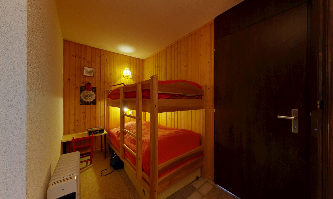 room / bedroom with radiator heating unit and wood walls