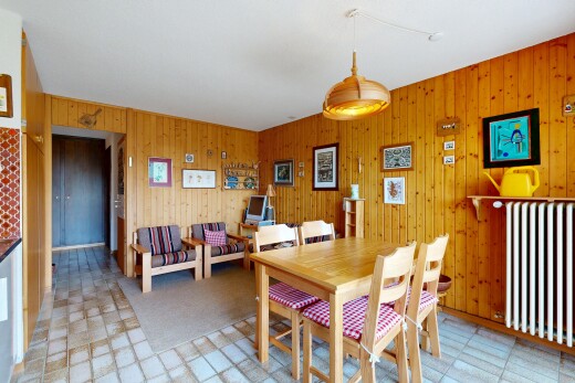 dining space featuring light floors, radiator heating unit, and wood walls