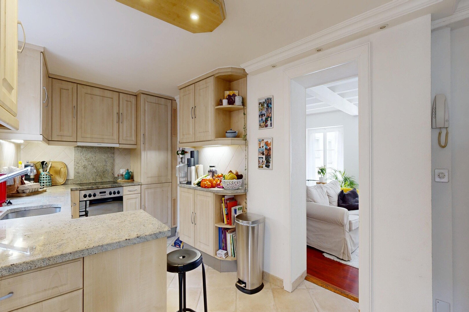 cuisine avec armoires marron clair, light brown cabinets, plans de travail en pierre, stone countertops, et light countertops