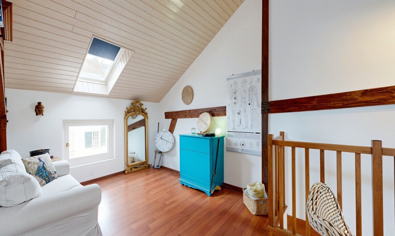 salon avec puits de lumière, cloison sèche, drywall, sol en finition bois, et wood finish floor