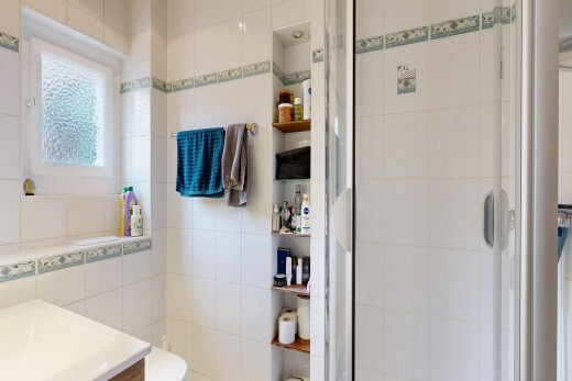 salle de bains avec lavabo (ou coiffeuse selon le contexte), tile wall, mur en carrelage, douche, et salle de bain complète