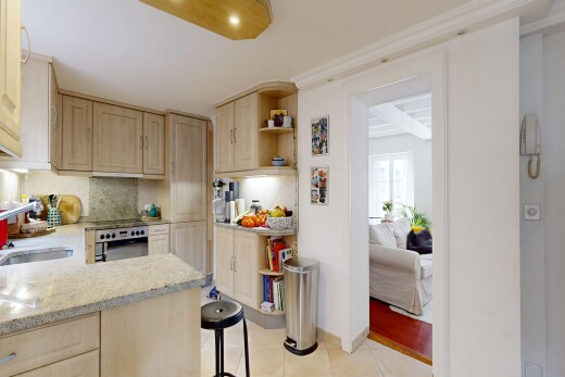 cuisine avec armoires marron clair, light brown cabinets, plans de travail en pierre, stone countertops, et light countertops