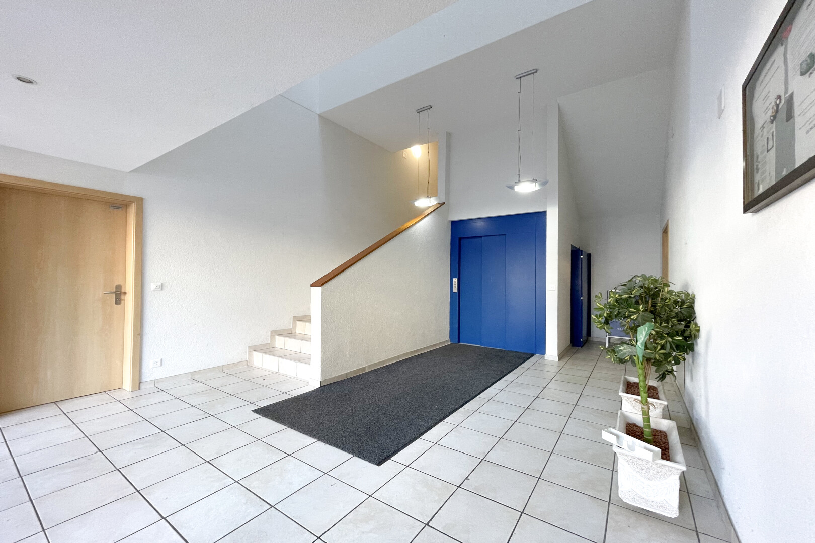 rezeption / lobby mit high ceiling, inside community, drywall, treppen, und tile floor