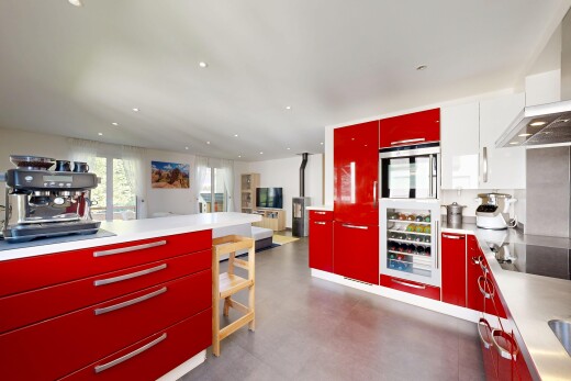 cuisine avec red cabinets, armoires rouges, hotte, light countertops, et plans de travail