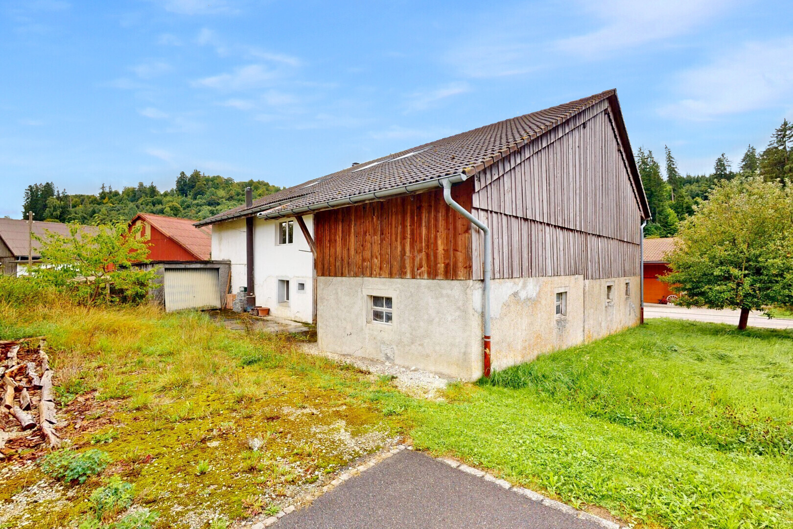 façade avec bardage vertical, fondation en béton, day time, property visible, et bardage en bois