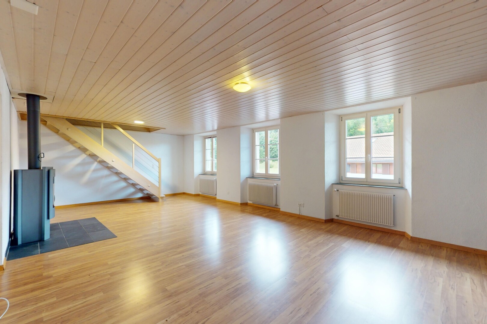 pièce vide avec sol en finition bois, wood finish floor, radiateur, escaliers, et plafond en bois