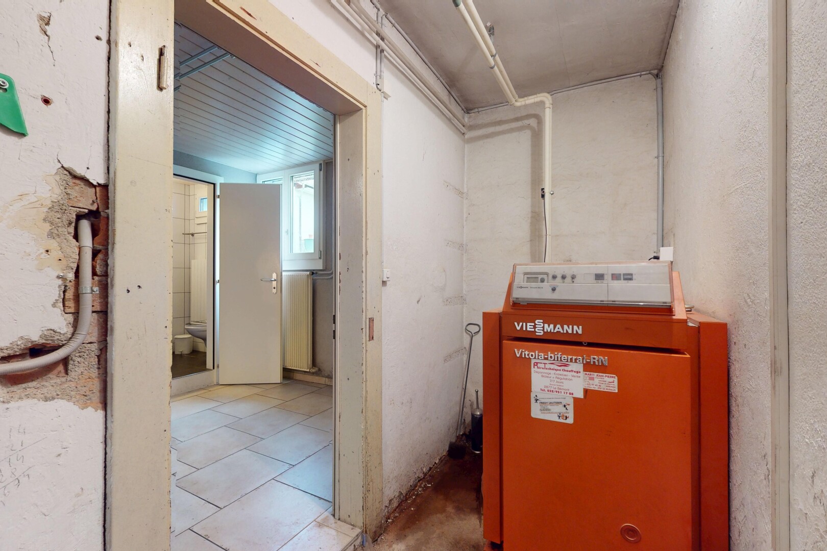 buanderie avec natural light, lumière naturelle, inside property, sous-sol, et radiateur