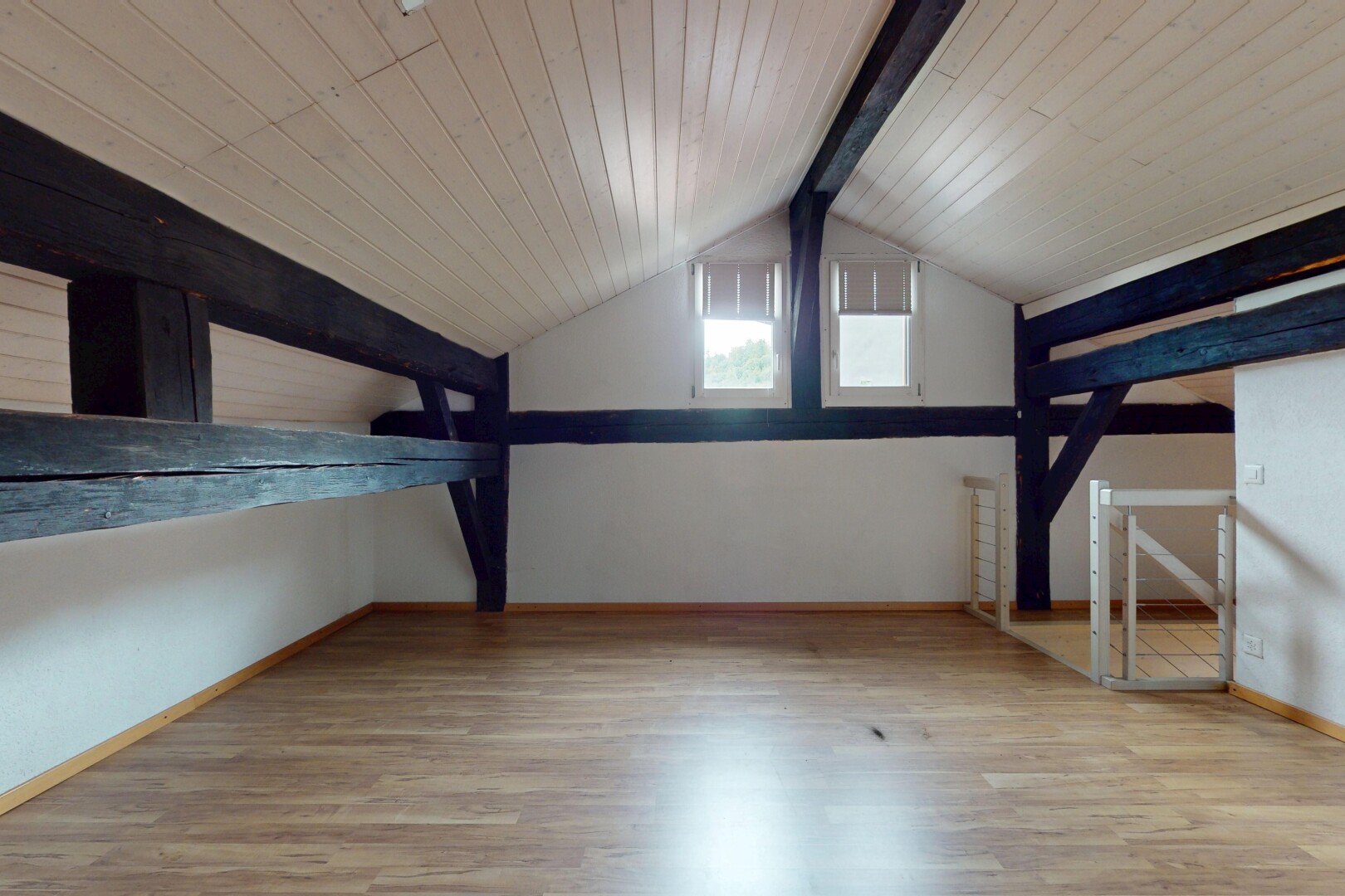 pièce vide avec beamed ceiling, plafond à poutres, wood finish floor, sol en finition bois, et inside property