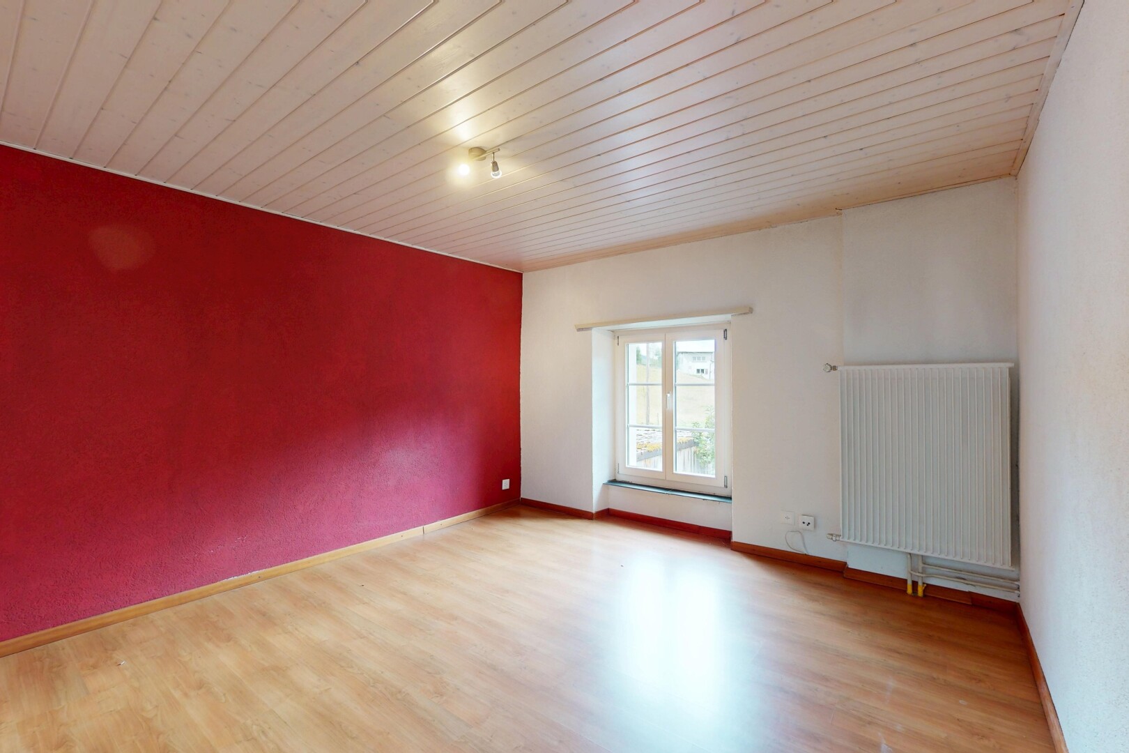 pièce vide avec radiateur, lumière naturelle, natural light, sol en finition bois, et wood finish floor