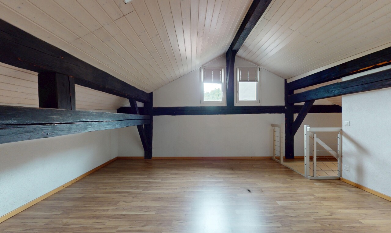 pièce vide avec beamed ceiling, plafond à poutres, wood finish floor, sol en finition bois, et inside property