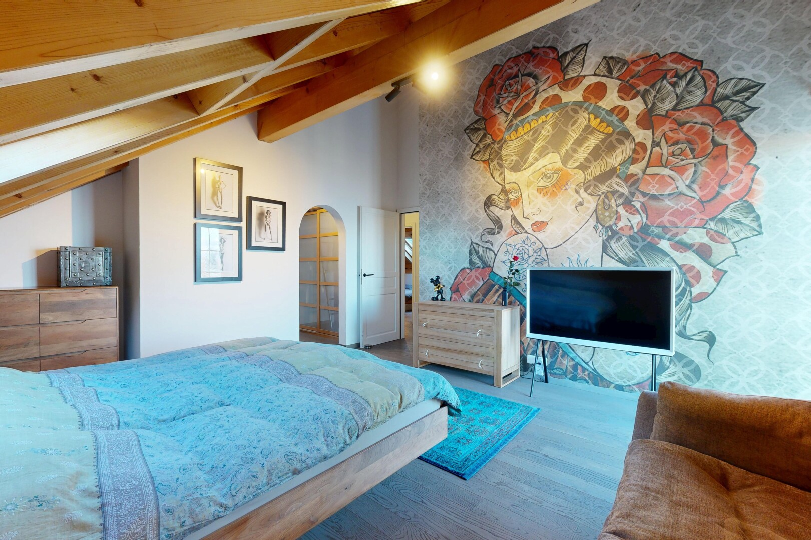 chambre avec télévision, sol en finition bois, wood finish floor, plafond voûté, et vaulted ceiling