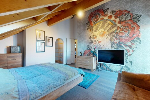 chambre avec télévision, sol en finition bois, wood finish floor, plafond voûté, et vaulted ceiling