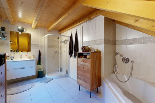 bathroom featuring a stall shower, vanity, tiled bath, light tile patterned floors, and a wooden ceiling with exposed beams