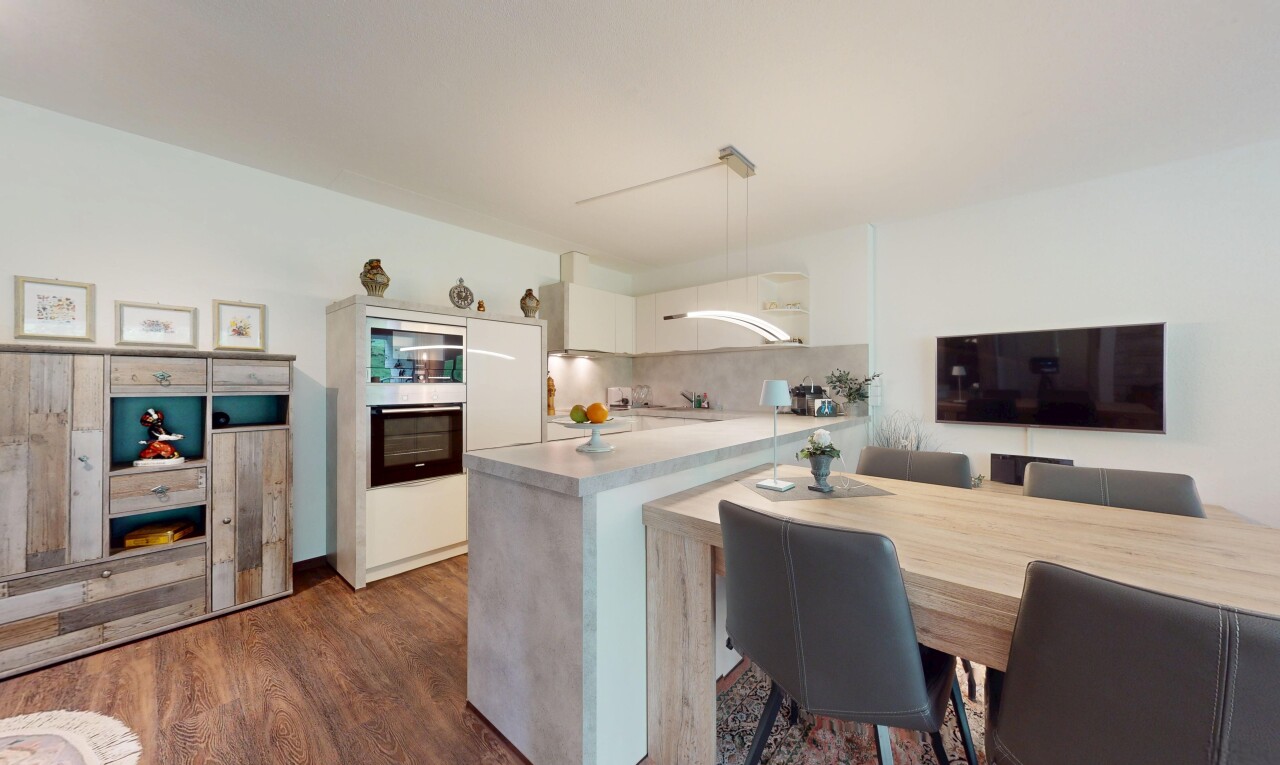 küche mit fernseher, ofen, holzfußboden, wood finish floor, und küchenrückwand beim herd