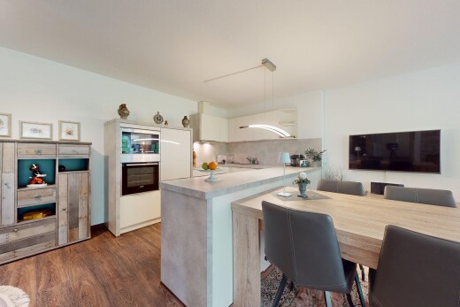 küche mit fernseher, ofen, holzfußboden, wood finish floor, und küchenrückwand beim herd