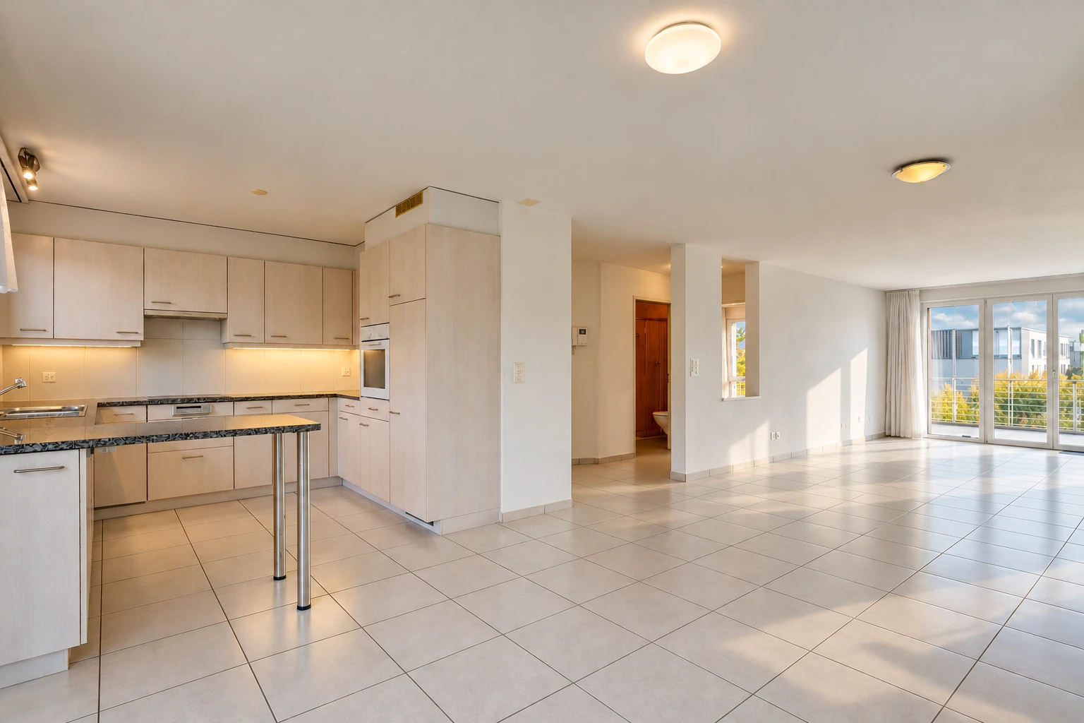 cuisine avec dark countertops, ouvert sur l'espace de vie, opens to living area, light floor, et cloison sèche