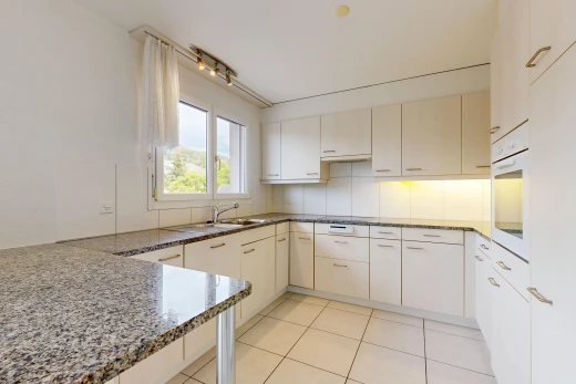 cuisine avec plans de travail en pierre, stone countertops, four, light floor, et sol en carrelage