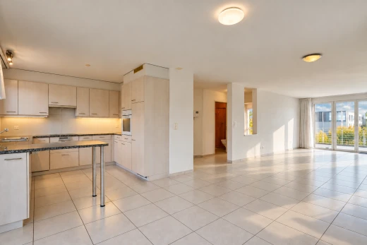 cuisine avec dark countertops, ouvert sur l'espace de vie, opens to living area, light floor, et cloison sèche