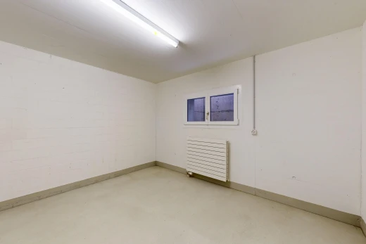 pièce vide avec sol en béton, concrete floor, radiateur, inside community, et plinthes murales