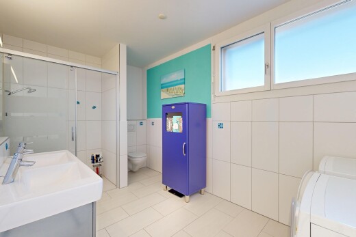 salle de bains avec tile wall, mur en carrelage, salle de bain complète, douche, et double vasque