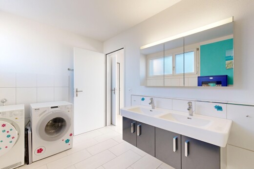 salle de bains avec lave-linge et sèche-linge, double vasque, salle de bain complète, light floor, et évier
