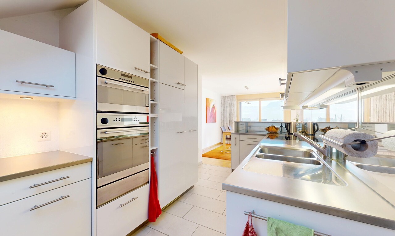 cuisine avec armoires blanches, four double, inside property, plans de travail, et évier