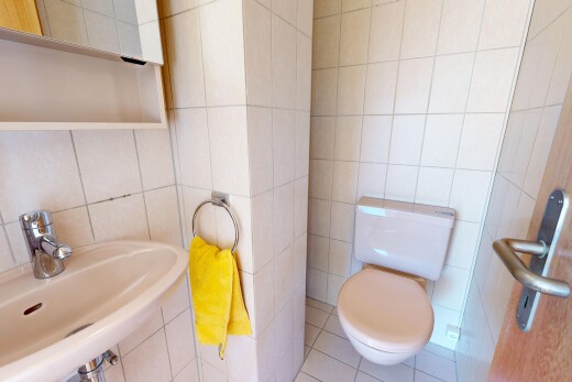 salle de bains avec mur en carrelage, tile wall, toilette, évier, et sol en carrelage