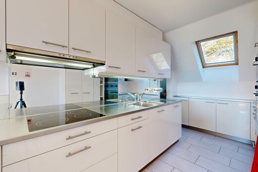 cuisine avec armoires blanches, hotte, plaque de cuisson, lumière naturelle, et natural light