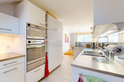 cuisine avec armoires blanches, four double, inside property, plans de travail, et évier