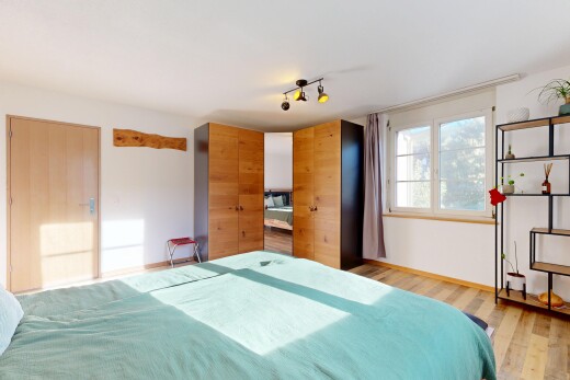 zimmer / schlafzimmer mit kleiderschrank, drywall, gipskartonwand, wood finish floor, und holzfußboden