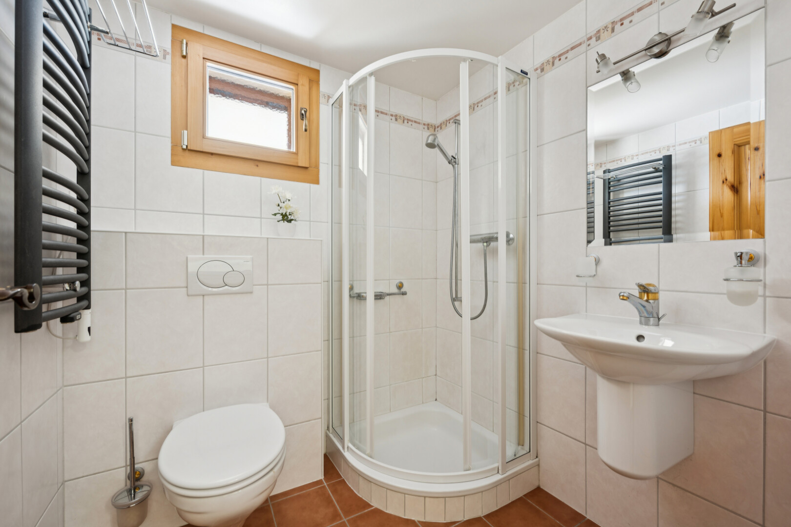 salle de bains avec chauffe-serviettes, salle de bain complète, douche, miroir, et mur en carrelage
