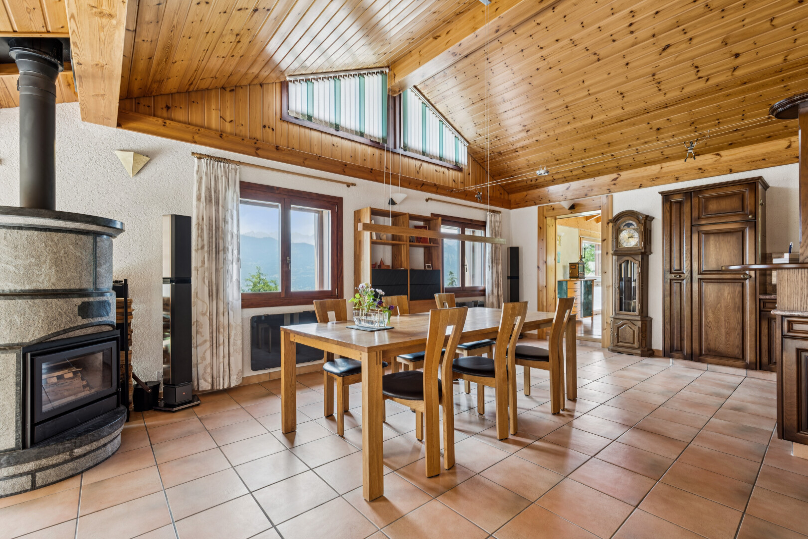 salle à manger avec high end ceiling, poêle à bois, plafond à poutres, beamed ceiling, et plafond voûté
