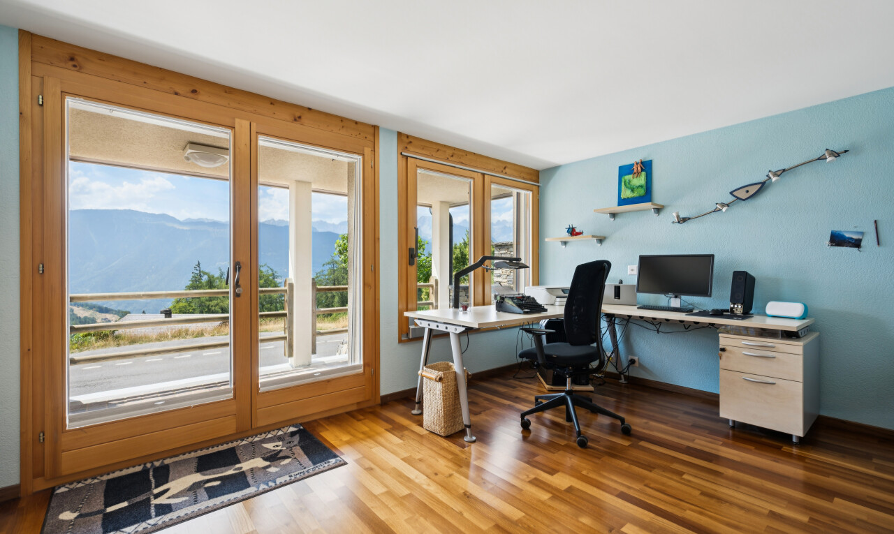 bureau avec sol en finition bois, wood finish floor, cloison sèche, drywall, et télévision