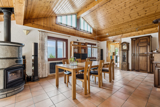 salle à manger avec high end ceiling, poêle à bois, plafond à poutres, beamed ceiling, et plafond voûté