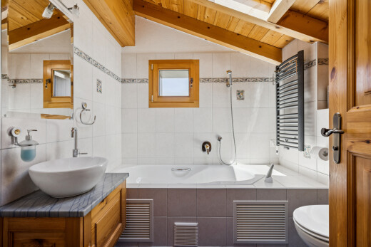 salle de bains avec vaulted ceiling, plafond voûté, tile wall, mur en carrelage, et miroir