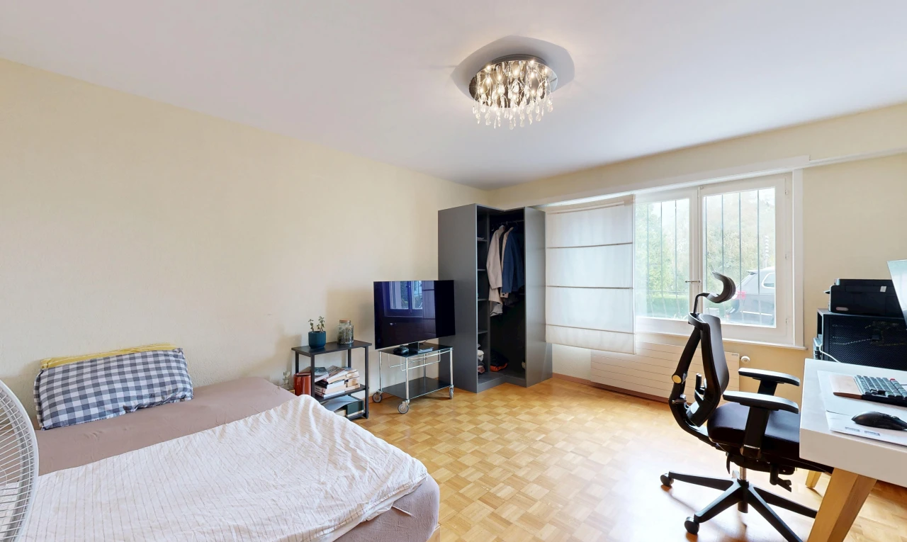 chambre avec espace bureau, wood finish floor, sol en finition bois, drywall, et cloison sèche