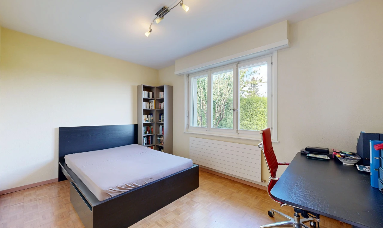 chambre avec éclairage sur rail, drywall, cloison sèche, radiateur, et wood finish floor