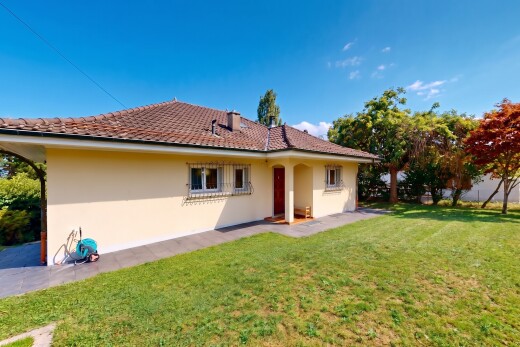 view of home featuring a tile roof, a lawn, and stucco siding