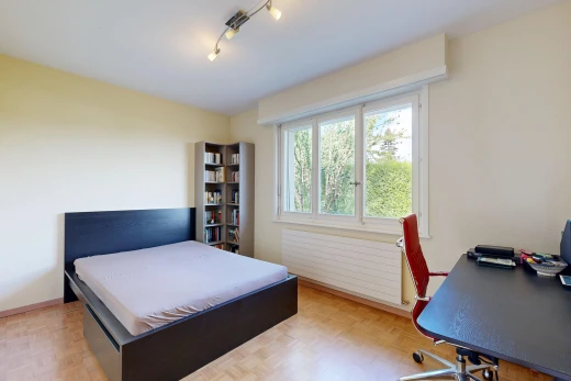 chambre avec éclairage sur rail, drywall, cloison sèche, radiateur, et wood finish floor