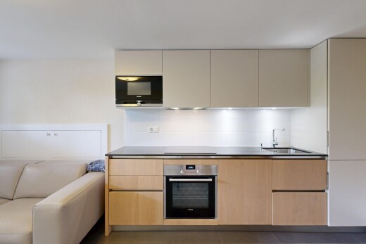 two tone kitchen featuring two tone color scheme, stainless steel oven, black microwave, modern cabinets, and dark countertops