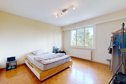 room / bedroom featuring rail lighting, radiator heating unit, and parquet floors