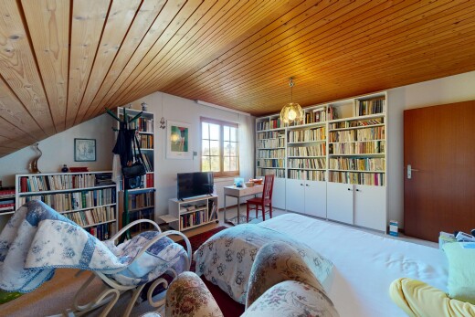 zimmer / schlafzimmer mit natürliches licht, natural light, inside property, fernseher, und niedrige decke